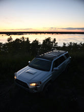 Load image into Gallery viewer, Pictured in the darkening late evening light is a silver Toyota SUV, specifically a 5th Gen 4Runner with the assembled 10-20 4Runner 5th Gen Modular Roof Rack on the car roof. The perfect fit and most compatible choice of modular roof rack for your Toyota 4Runner 5th Gen SUV! Available for sale by SMRT Tent in Edmonton, Canada.