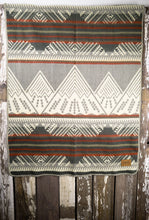 Load image into Gallery viewer, Pictured is a red, grey, dark grey, pale green and white coloured, mountain patterned baby blanket. This is the Heartprint Threads 'Little Climber' Baby Blanket, created by Ecuadorian Artisans. Perfect for your everyday soft & warm baby blanket needs! Available for sale at SMRT Tent in Edmonton, Canada.