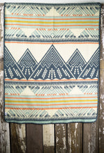 Load image into Gallery viewer, Pictured is a light blue, orange, golden yellow, light grey, dark slate blue and cream coloured, mountain patterned baby blanket. This is the Heartprint Threads 'Mountain Lion' Baby Blanket, created by Ecuadorian Artisans. Perfect for your everyday soft & warm baby blanket needs! Available for sale at SMRT Tent in Edmonton, Canada.