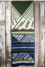 Load image into Gallery viewer, Pictured is a rich olive green, white, golden brown & dark blue, mountain-patterned, laid-out and slim folded blanket. This is the Heartprint Threads 'Rolling Hills' Mountain Flakes Line Queen Blanket, created by Ecuadorian Artisans. Throw this warm blanket over your sleeping bag while camping outdoors! Available for sale at SMRT Tent in Edmonton, Canada.