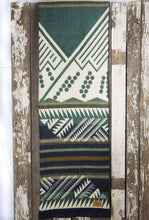 Load image into Gallery viewer, Pictured is a green, white & dark blue, mountain-patterned, laid-out and slim folded blanket. This is the Heartprint Threads 'Tracing the Columbia' Mountain Flakes Line Queen Blanket, created by Ecuadorian Artisans. Throw this warm blanket over your sleeping bag while camping outdoors! Available for sale at SMRT Tent in Edmonton, Canada.