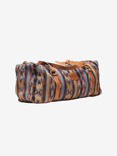 Load image into Gallery viewer, Pictured is a dark blue, light blue, black, terracotta brown, tan and brown patterned bag (similar looking to a duffle bag) with soft, brown leather straps. This is the Heartprint Threads 'Cartagena 2.0' Weekend Traveller Bag, created by Ecuadorian Artisans. Perfect for all your week-long packing, storing and travelling needs! Available for sale at SMRT Tent in Edmonton, Canada.