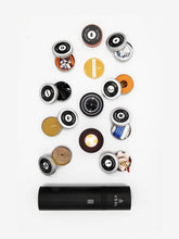 Load image into Gallery viewer, Pictured foremost, is the unpacked Black cylinder. In a 4 by 3 grid are 10 tins with their tops open. Starting at the left-most line, move upwards and to the next line: 1. rope+razor kit , 2. beeswax candle, 3. VSSL wire saw, 4. miscellaneous gear kit, 5. flashlight end cap, 6. compass end cap, 7. bamboo cloth, 8. VSSL adventure tape, 9. firestarter kit, 10. first aid kit, 11. fishing kit, 12. water purification kit. Available for sale by SMRT Tent in Edmonton, Canada.