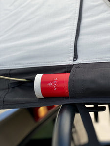 Pictured is a close-up view of an outside side pocket from a light grey, completely set-up softshell roof top tent. This is “The” Softshell, a roof top tent perfect for all overland roof top tent family outdoor camping! Available for sale by SMRT Tent in Edmonton, Canada.