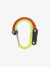 Load image into Gallery viewer, Pictured in orange for the swivel hook and bright yellow for the rest of the clip is a closed, medium-sized metal carabiner. This is the HeroClip Medium in Fireball. Perfect for your roof top tent adventure camp tool hanging needs! Available for sale by SMRT Tent in Edmonton, Canada.
