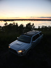 Load image into Gallery viewer, Pictured in the darkening late evening light is a silver Toyota SUV, specifically a 5th Gen 4Runner with the assembled 10-20 4Runner 5th Gen Modular Roof Rack on the car roof. The perfect fit and most compatible choice of modular roof rack with extra bars for your Toyota 4Runner 5th Gen SUV! Available for sale by SMRT Tent in Edmonton, Canada.
