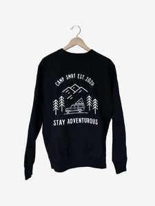  Pictured is the back of a Black Crewneck sweatshirt which depicts in white outline; three mountains overlapping and 4 simple pine trees surrounding a Land Rover Defender 110 SUV with a hard shell roof top tent on its roof rack. The words above the image say Camp SMRT EST 2020 and are written in white. With the same for the words below the image that say Stay Adventurous. nt in this comfy crew! Available for sale by SMRT Tent in Edmonton, Canada.