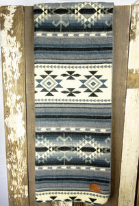 Pictured is a blue & grey, patterned and laid-out blanket. This is the Heartprint Threads ‘Ocean Layers’ Aztec Series Double Blanket, created by Ecuadorian Artisans. Throw this warm blanket over your sleeping bag while camping outdoors! Available for sale at SMRT Tent in Edmonton, Canada.