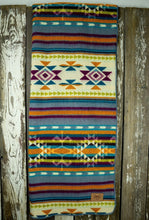 Load image into Gallery viewer, Pictured is a rainbow-coloured, patterned and laid-out blanket. This is the Heartprint Threads ‘Stardust’ Aztec Series Double Blanket, created by Ecuadorian Artisans. Throw this warm blanket over your sleeping bag while camping outdoors! Available for sale at SMRT Tent in Edmonton, Canada.
