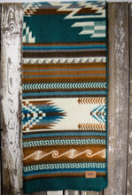 Load image into Gallery viewer, Pictured is a dark teal, blue &amp; brown, wave-patterned and laid-out blanket. This is the Heartprint Threads &#39;Country Roads&#39; Maskuy Collection Queen Blanket, created by Ecuadorian Artisans. Throw this warm blanket over your sleeping bag while camping outdoors! Available for sale at SMRT Tent in Edmonton, Canada.
