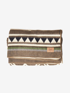 Pictured is a brown, patterned and neatly folded blanket. This is a Heartprint Threads Tree Line Queen Blanket, created by Ecuadorian Artisans. Throw this warm blanket over your sleeping bag while camping outdoors! Available for sale at SMRT Tent in Edmonton, Canada.