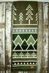 Pictured is a green, patterned and laid-out blanket. This is the Heartprint Threads 'Ponderosa' Tree Line Queen Blanket, created by Ecuadorian Artisans. Throw this warm blanket over your sleeping bag while camping outdoors! Available for sale at SMRT Tent in Edmonton, Canada.