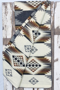 Pictured is a slate-coloured, patterned, laid-out and folded-out blanket. This is the Heartprint Threads 'Anchor' Queen Blanket, created by Ecuadorian Artisans. Throw this warm blanket over your sleeping bag while camping outdoors! Available for sale at SMRT Tent in Edmonton, Canada.