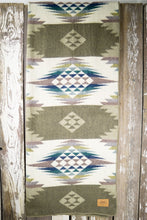 Load image into Gallery viewer, Pictured is an olive green, patterned and laid-out blanket. This is the Heartprint Threads &#39;Coral Bits&#39; Queen Blanket, created by Ecuadorian Artisans. Throw this warm blanket over your sleeping bag while camping outdoors! Available for sale at SMRT Tent in Edmonton, Canada.
