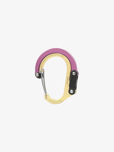 Pictured in metallic dusty rose for the closed swivel hook and light gold for the rest of the clip, is a small-sized metal carabiner. This is the HeroClip Small in Gold and Dusty Rose. Perfect for your roof top tent adventure camp tool hanging needs! Available for sale by SMRT Tent in Edmonton, Canada.