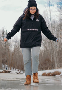 Pictured is our model in full frame of the camera. She is wearing our SMRT Tent Rainy Jacket (in Black) while she walks on a slightly cracked, frozen lake in classic Timberlands. Layer around your SMRT Tent roof top tent camp or Tacoma in this sweet anorak! Available for sale by SMRT Tent in Edmonton, Canada.